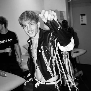 Bobnar skupine Joker Out v jakni, okrašeni z idrijsko čipko